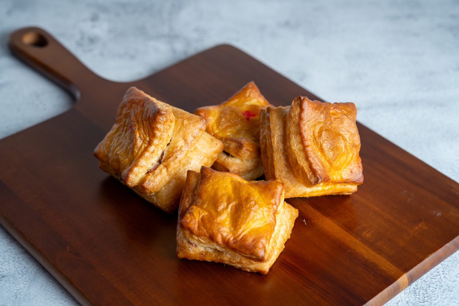 Vietnamese pastry pie, Pat&ecirc; S&ocirc;, golden-brown flaky layers on wooden board, featured in Carrot & Daikon menu.