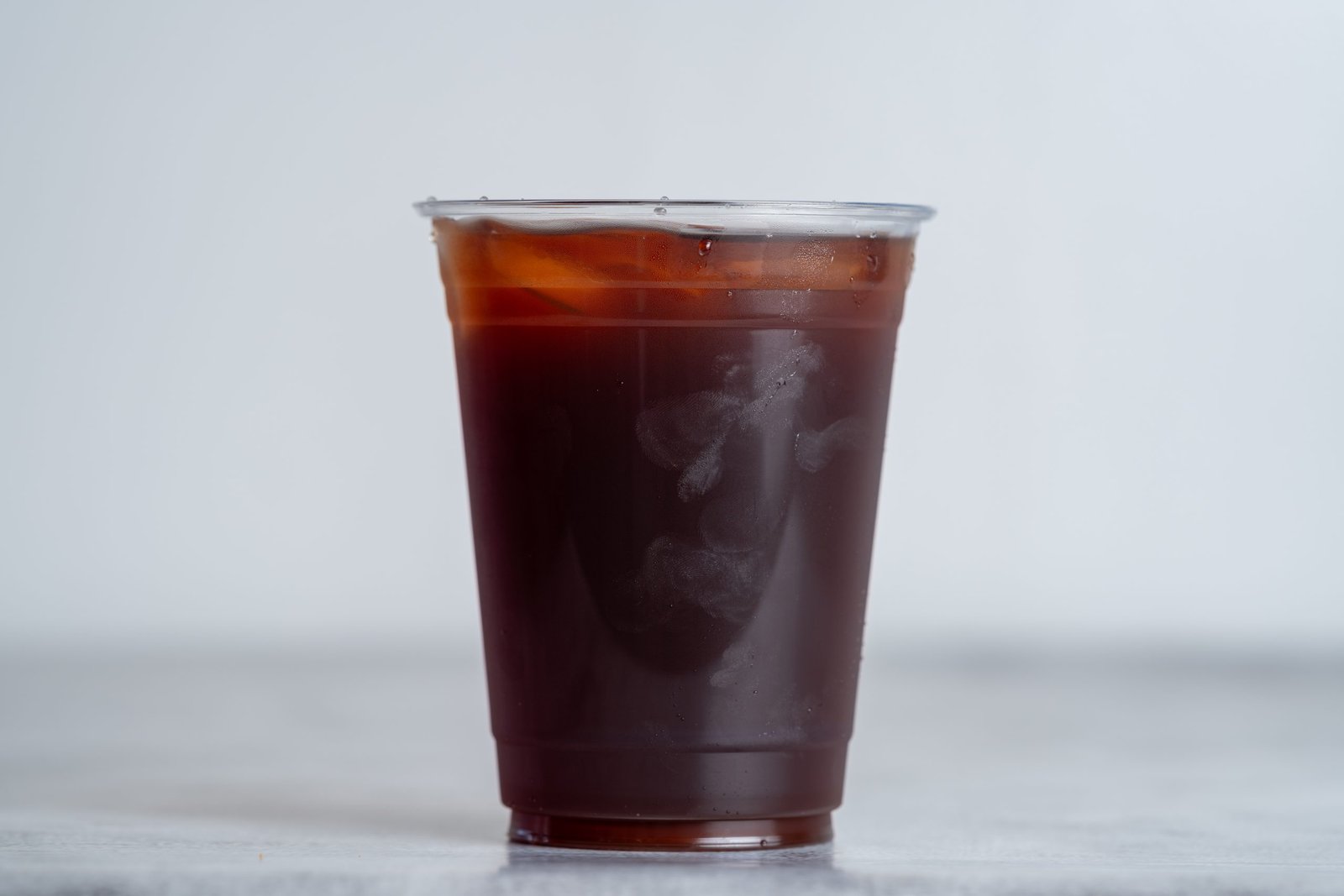 Iced Vietnamese coffee in a clear cup, showcasing the rich dark color and condensation on the outside, representing Carrot & Daikon's beverage offerings.